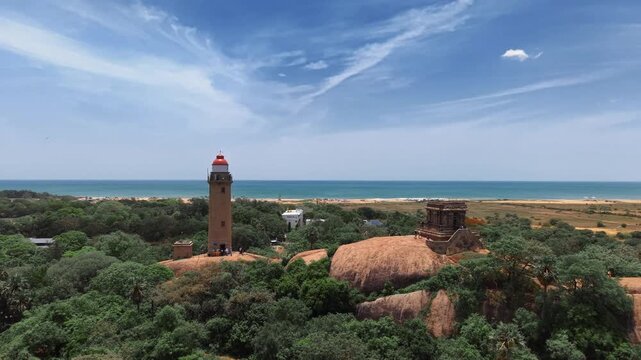 Lighthouse rising above ancient monuments near the Mahabalipuram coast