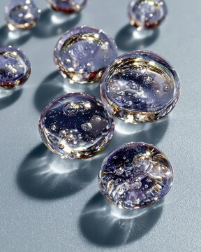 Shiny serum drops clear glass bubbles on blue surface close up