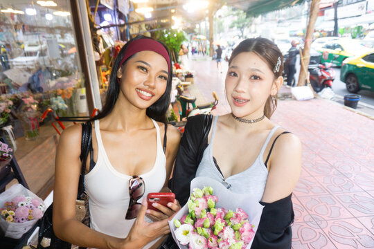 Portrait of two authentic Gen Z asian women enjoy at  flower marke