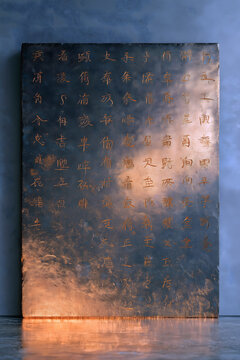 Centered front view of bluestone stele, incised regular script light strokes, golden light flowing from deep carvings, subtle weathering cracks and pits, top-down lighting, monumental simplicity asset
