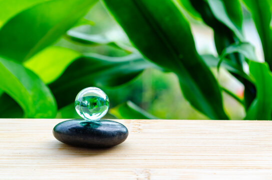 Smooth black zen stones with a crystal sphere representing balance, calmness, mindfulness, and inner peace.