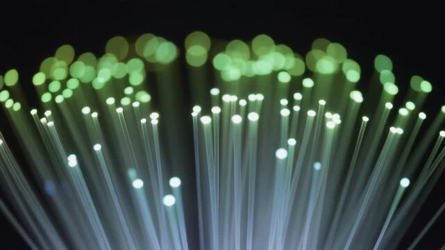 Fiber optic cable network transmitting glowing green data signal in digital communication concept