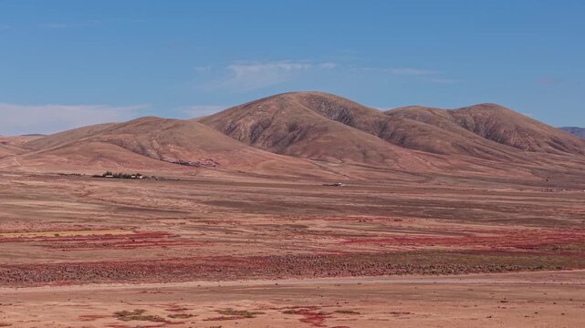 Aerial view of surroundings from El Cotillo, a coastal town located on the island of Fuerteventura, Canary Islands, Spain. Drone POV exploration of volcanic mountains and desert landscape.