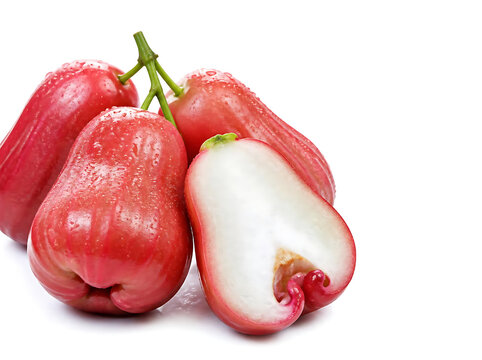 Close-up macro view of fresh rose apples clustered naturally with one sliced fruit in front, crisp juicy texture, subtle water droplets, vibrant natural colors, high sharpness