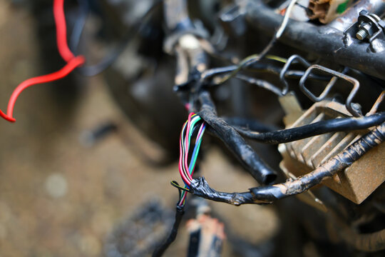 Exposed wire motorcycle repair electrical wiring cable damage shows hazardous mechanical problem requiring careful maintenance and troubleshooting in workshop setting