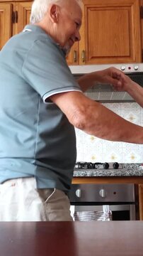 Joyful senior couple dancing and smiling together in their home kitchen, celebrating their long-lasting love and partnership with affectionate and playful movements in a heartwarming moment