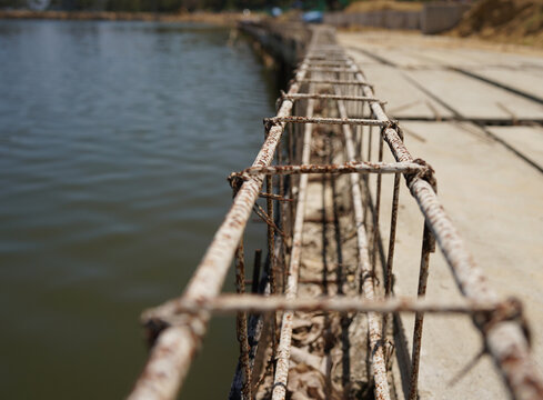 Building process city levee. Exposed foundation rebar grid at site, standing formwork and concrete footings
