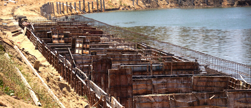 Building process city levee. Exposed foundation rebar grid at site, standing formwork and concrete footings