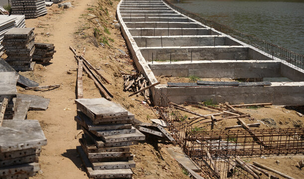 Building process city levee. Exposed foundation rebar grid at site, standing formwork and concrete footings