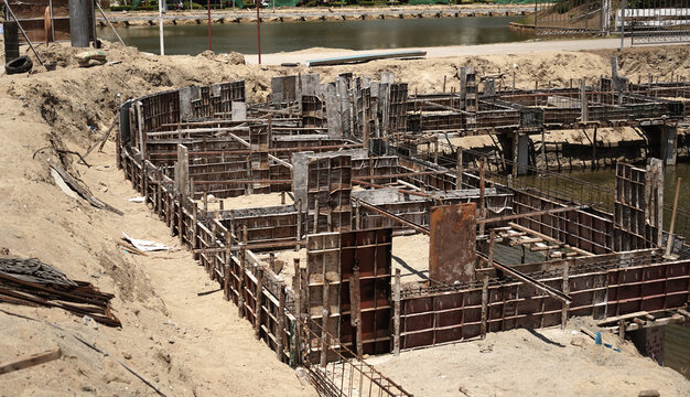 Building process city levee. Exposed foundation rebar grid at site, standing formwork and concrete footings