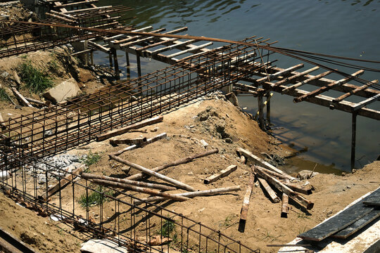 Building process city levee. Exposed foundation rebar grid at site, standing formwork and concrete footings