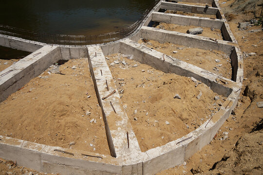 Building process city levee. Exposed foundation rebar grid at site, standing formwork and concrete footings