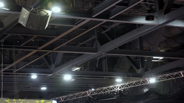Black Metal roof trusses and ceiling structure inside a large hall or center. Industrial steel framework supporting 