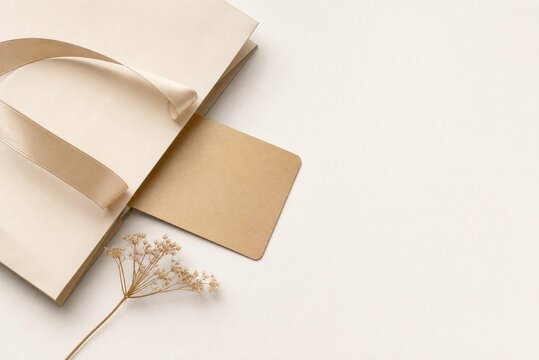 Minimalist paper shopping bag mockup, blank kraft card with dried flower, elegant retail packaging branding concept