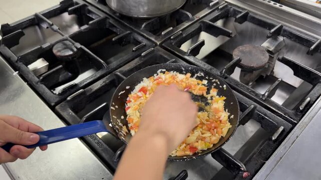 Chef cooking venezuelan arepas with hogao filling in a restaurant kitchen