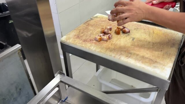Chef deep frying diced pancetta in a restaurant kitchen