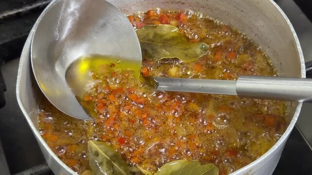 Preparing a simmering sofrito with vegetables and bay leaves