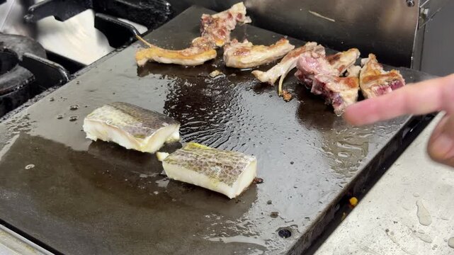 Chef cleaning a hot griddle with water in a professional kitchen