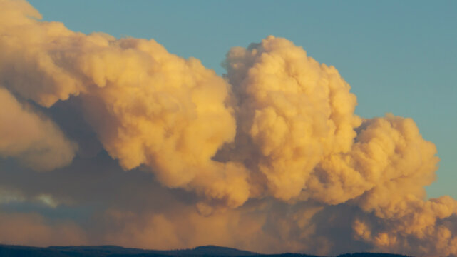 Billowing yellow smoke cloud from wildfire at sunset