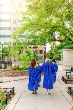 Young female graduates walking together outdoors