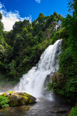Obraz premium Pha Dok Siew waterfall cascading down steep rocks in deep lush jungle at Doi Inthanon, Chiang Mai, Thailand. Tropical rainforest nature travel concept. Vertical orientation.