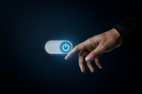 Finger touching a glowing power button icon on a dark background representing digital control