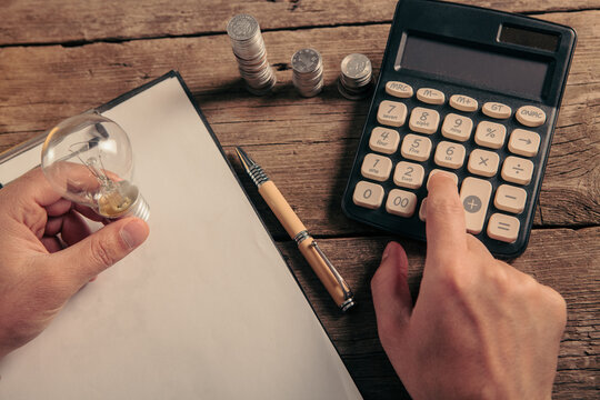 man hand with calculator and coins on table, business and finance concept