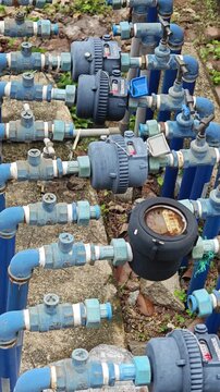 A complex system of blue water pipes and water meters installed outdoors
