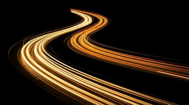 Long exposure photograph of winding road at night with blurred vehicle light trails illuminating the path