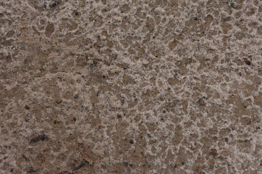 Close-up of wet sandy soil texture eroded by rain drops background
