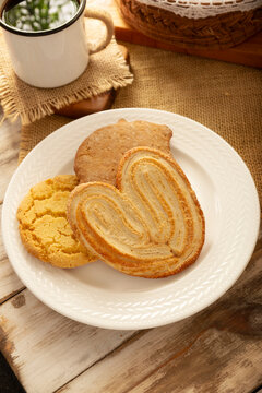 Traditional Mexican sweet bread variety on a rustic wooden board. Variety of authentic pan dulce including puerquito, orejas, and cookies over a neutral tablecloth background for bakery concept.