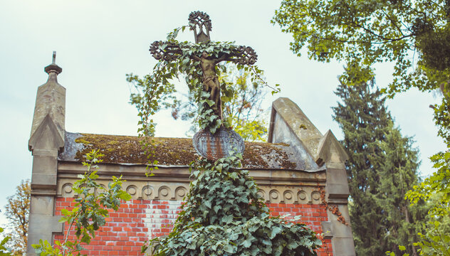 Ancient cemetery monuments featuring ornate gravestones, weathered stone sculptures and historic tombs surrounded by trees. Atmospheric old-world funerary architecture and timeless memorial details 