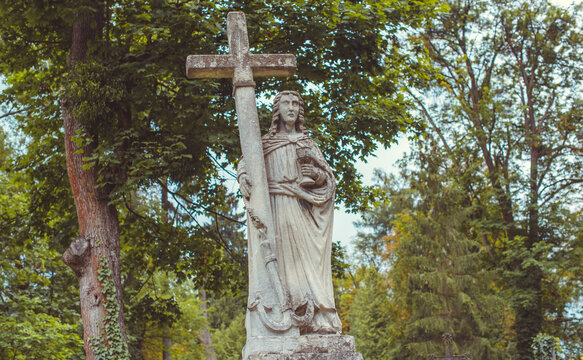 Ancient cemetery monuments featuring ornate gravestones, weathered stone sculptures and historic tombs surrounded by trees. Atmospheric old-world funerary architecture and timeless memorial details 