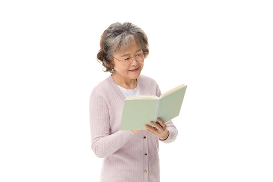 Smiling senior woman reading a book on white background