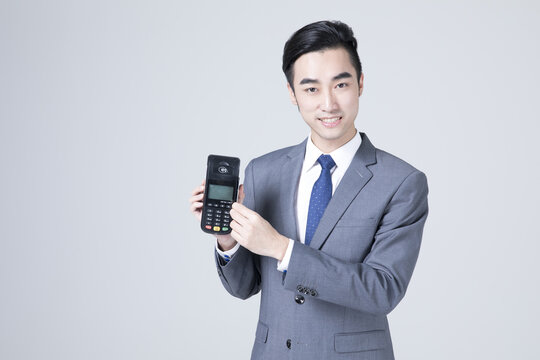 Businessman holding payment terminal and presenting card reader