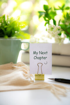 Notebook with my next chapter message on notepad inspiring new beginnings and future life planning.  Goal Life Wellness Concept.