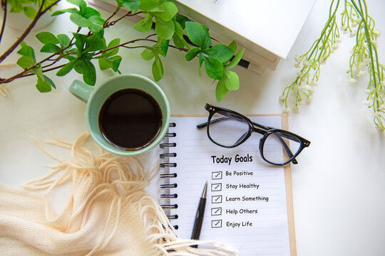 Notebook with today goal checklist on bright workspace for personal growth and future planning with coffee and green plants.  Goal Life Wellness Concept.