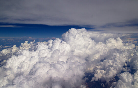 Aerial View Above Fluffy Cumulus Clouds Under Deep Blue Sky