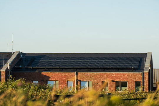Large Solar Panels Mounted on Brick Building Roof, The Concept of Renewable Energy