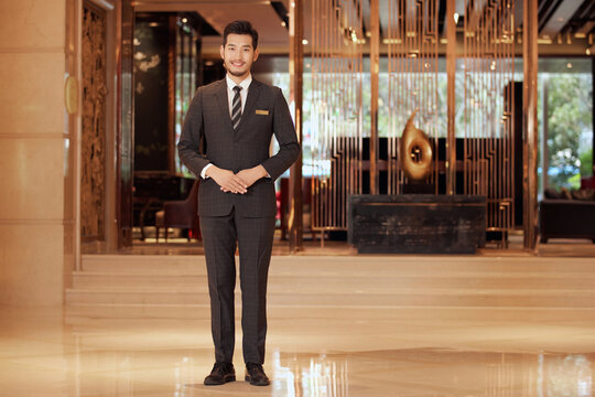 Professional hotel staff welcoming guests in luxury hotel lobby
