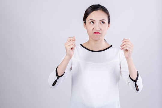 Disgusted young woman making uneasy gesture in studio