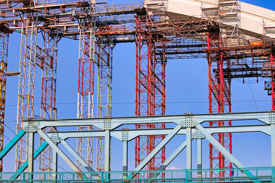 Close-up of industrial steel girder bridge structure with heavy-duty scaffolding and temporary shoring towers