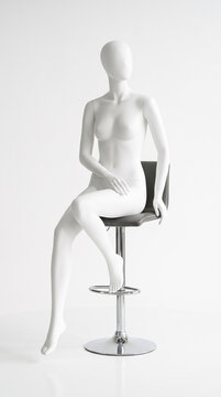 Maniqu&iacute; blanco s&oacute;lido sin costuras sentado en un taburete moderno.