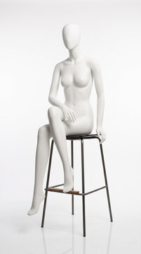 Maniqu&iacute; blanco s&oacute;lido sin costuras sentado en un taburete moderno.
