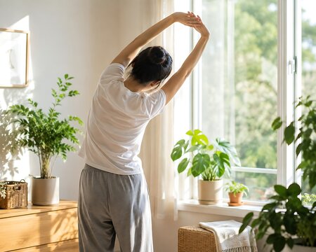 Woman stretching arms by window with indoor plants