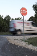 Van speeding past stop sign with motion blur © Lovec1