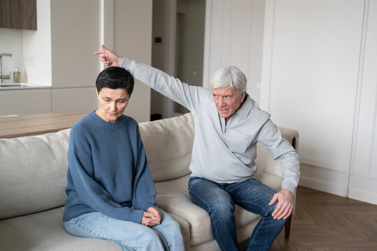 Aggressive senior man gesturing showing to exit, gaslighting wife in abusive communication at home. Marital conflict, toxic relationship, dependency struggle, woman suffering, elderly family crisis