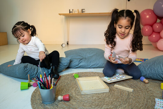 Little girls engaged in playtime and learning activities on the floor