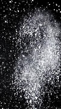 White Powder Particles Exploding and Falling Against a Black Background