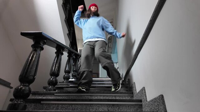 Young Woman in Red Beanie Freestyle Dancing Hip Hop on a Staircase in a Modern Building Lobby
